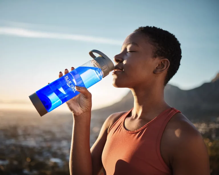 black woman drinking phycocyanine on bottle